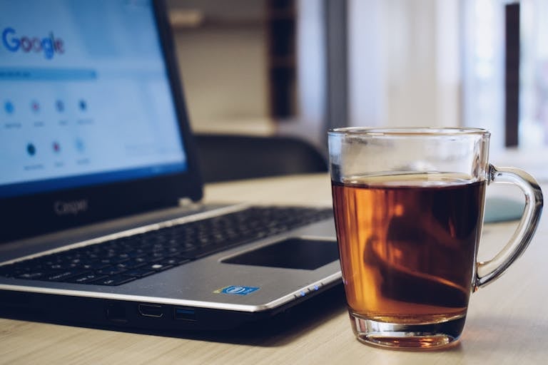 A Cup of Tea Beside a Laptop